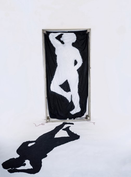 Sleeping Shadows. A black and a white bedsheet sewen together to highlight a figure, this shows a duality between the two figures as they were cut from the same sheet. Highlighting an absence and presence at the same time.