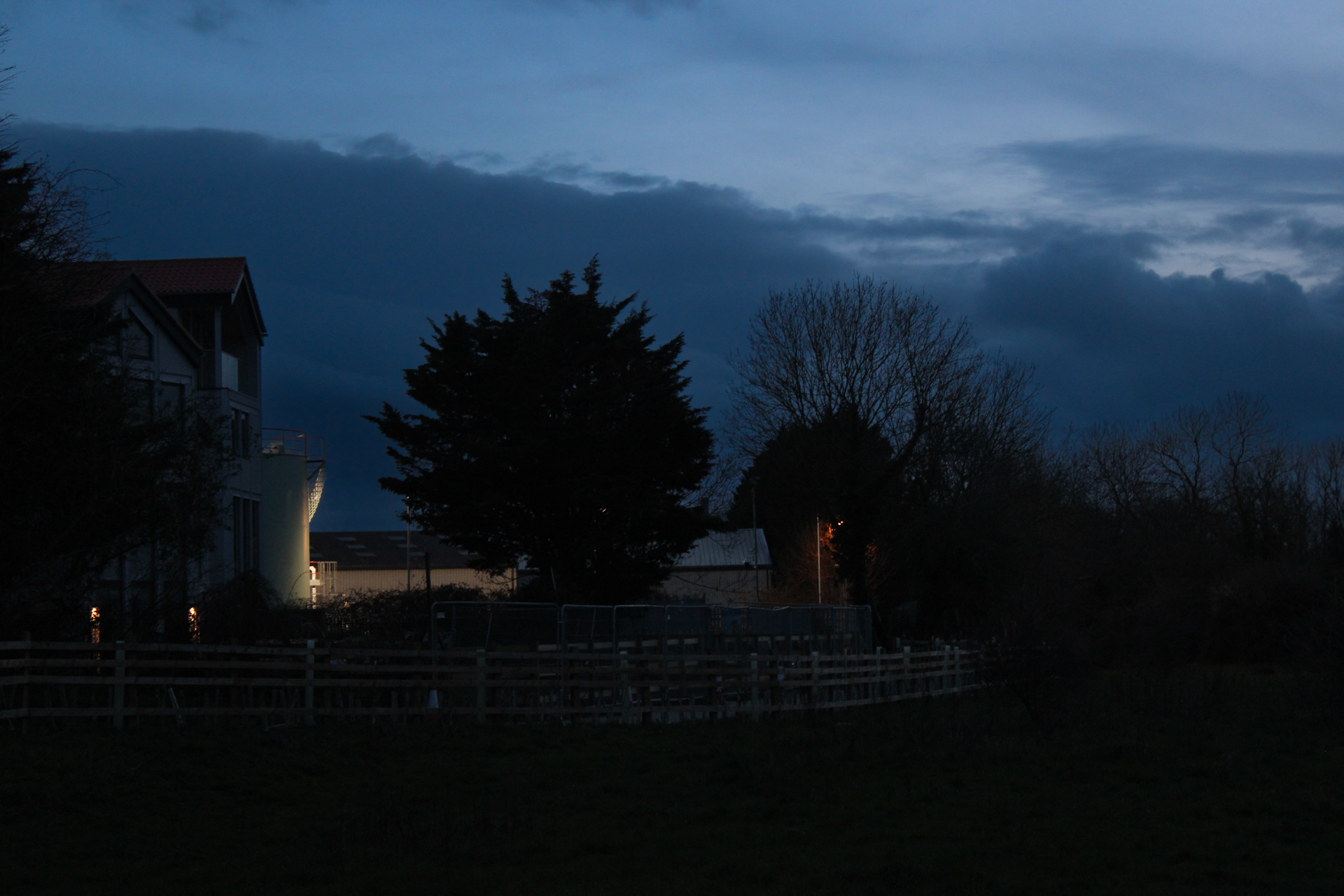 A house and surrounding fields during Blue Hour